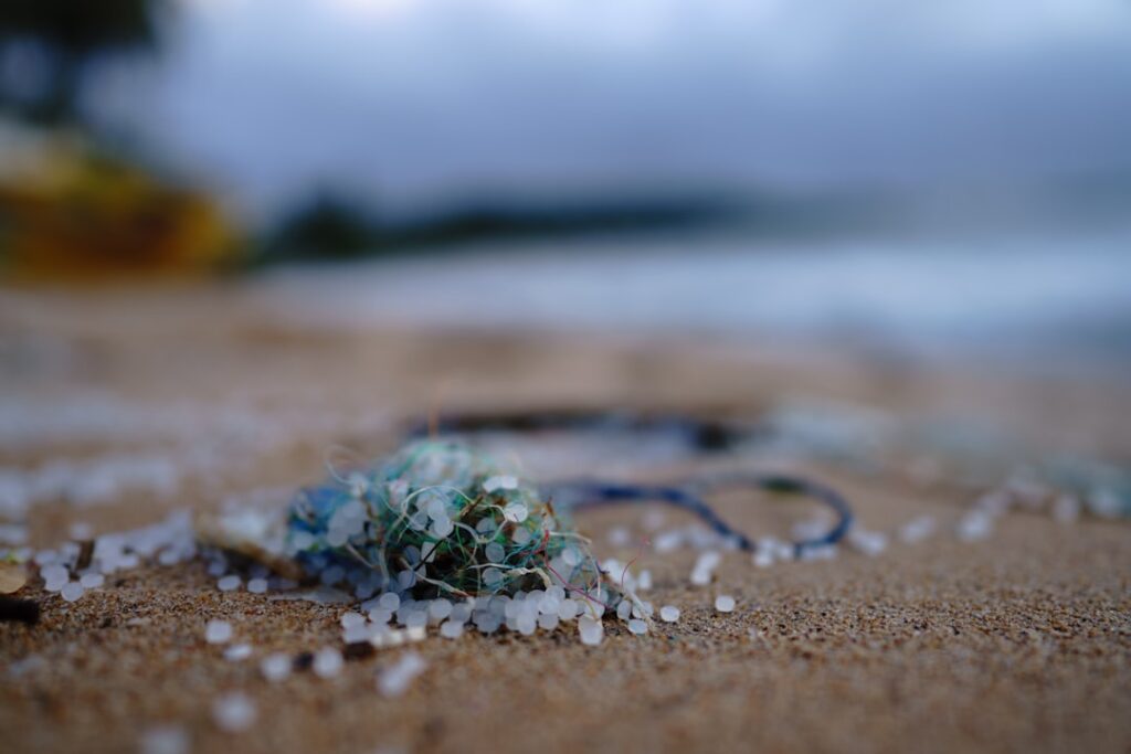 close up visual of microplastics on top of sand shown on a beach